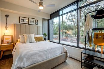 A bedroom with a bed and a large window